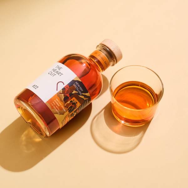 New Riff Kentucky bourbon bottle with tasting glass on beige surface
