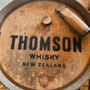 Wooden whisky barrel with 'Thomson Whisky New Zealand' branding.

