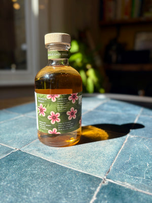 Bottle of whisky with a floral label on a tiled surface

