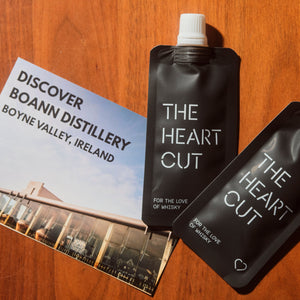 Two black pouches labeled 'The Heart Cut' and a promotional leaflet on a wooden surface.